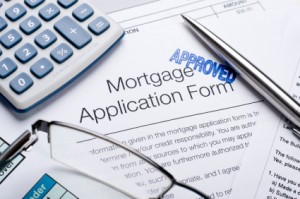 Approved Mortgage application form with a calculator, pen and glasses